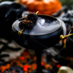 a pomegranate drink made with apple cider and lemon juice in a black glass