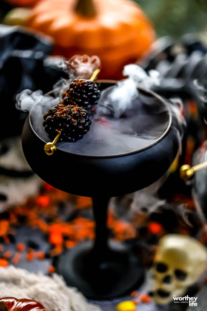 Pomegranate Potion in a black couple glass with dry ice.