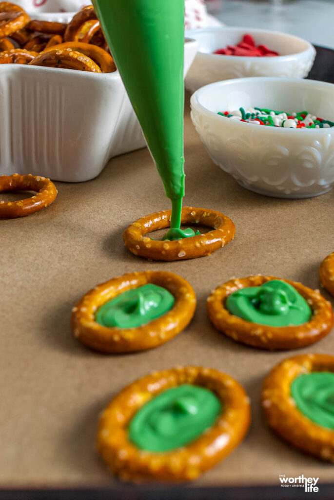 Filling pretzel rings with green candy melt