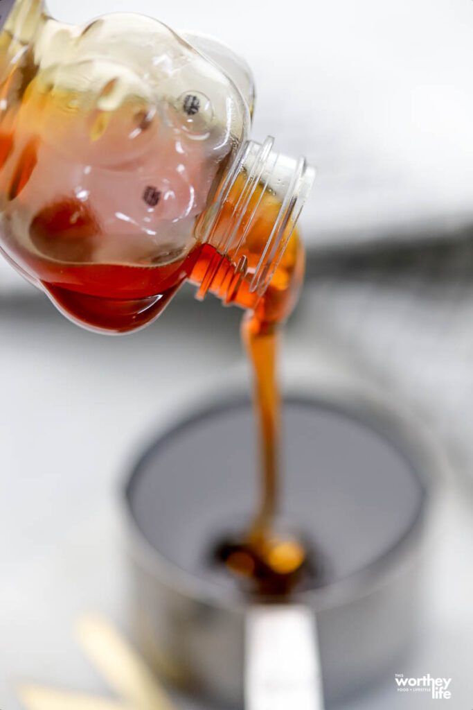 a honey bear container being poured into a measuring cup.