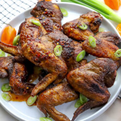 homemade jerk seasoned chicken wings on a white plate.