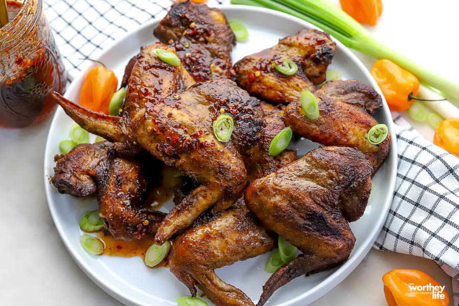 homemade jerk seasoned chicken wings on a white plate. 