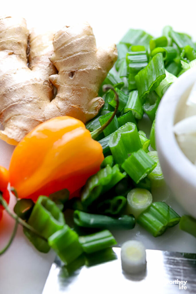 Jerk chicken marinade ingredients include peppers, onions, garlic, ginger, and scallions, etc.