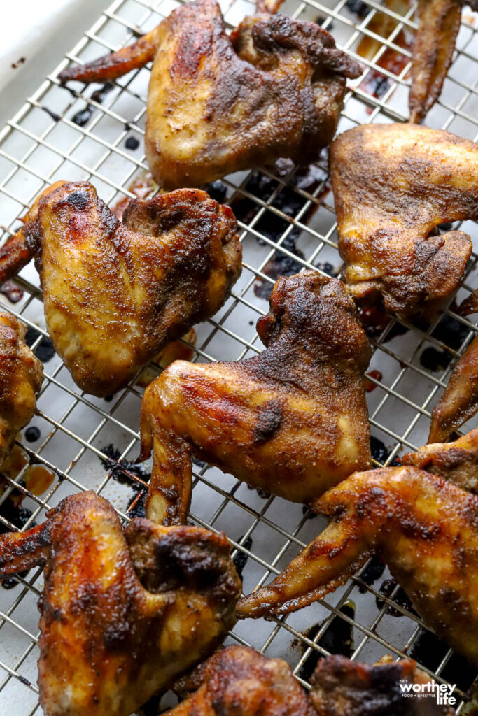 Cooked jerk chicken wings placed on a wire rack.