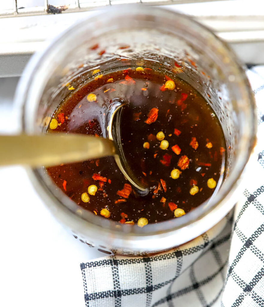 Hot honey stored in a glass jar with a spoon. 