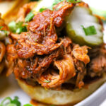 Pork Birria on slider buns with pickles.