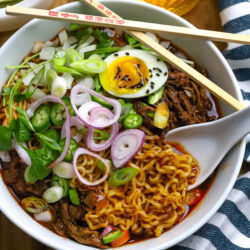 a bowl of birria pork ramen in a white serving bowl.