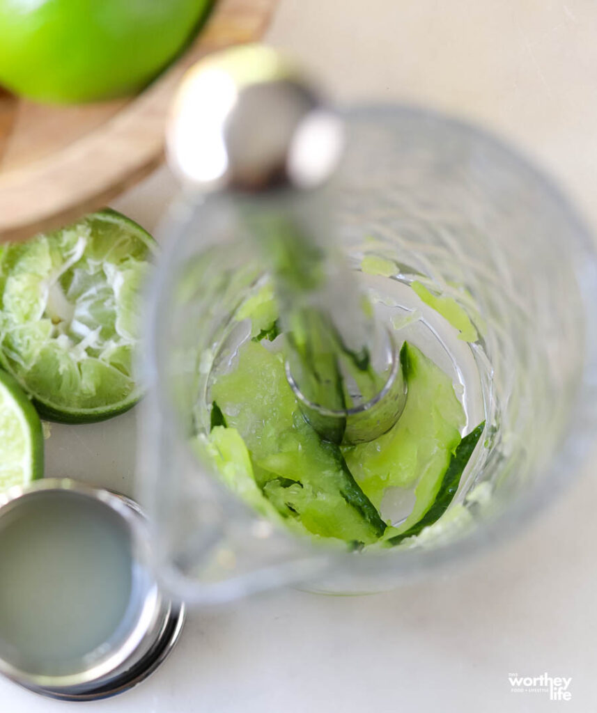 Muddling fresh cucumber in cocktail shaker