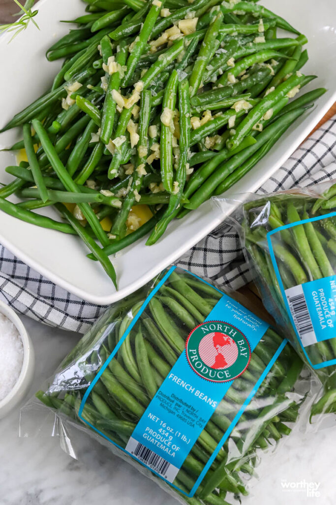 Packages of North Bay Produce French Green Beans and a serving dish with our Honey Garlic Butter Green Beans.