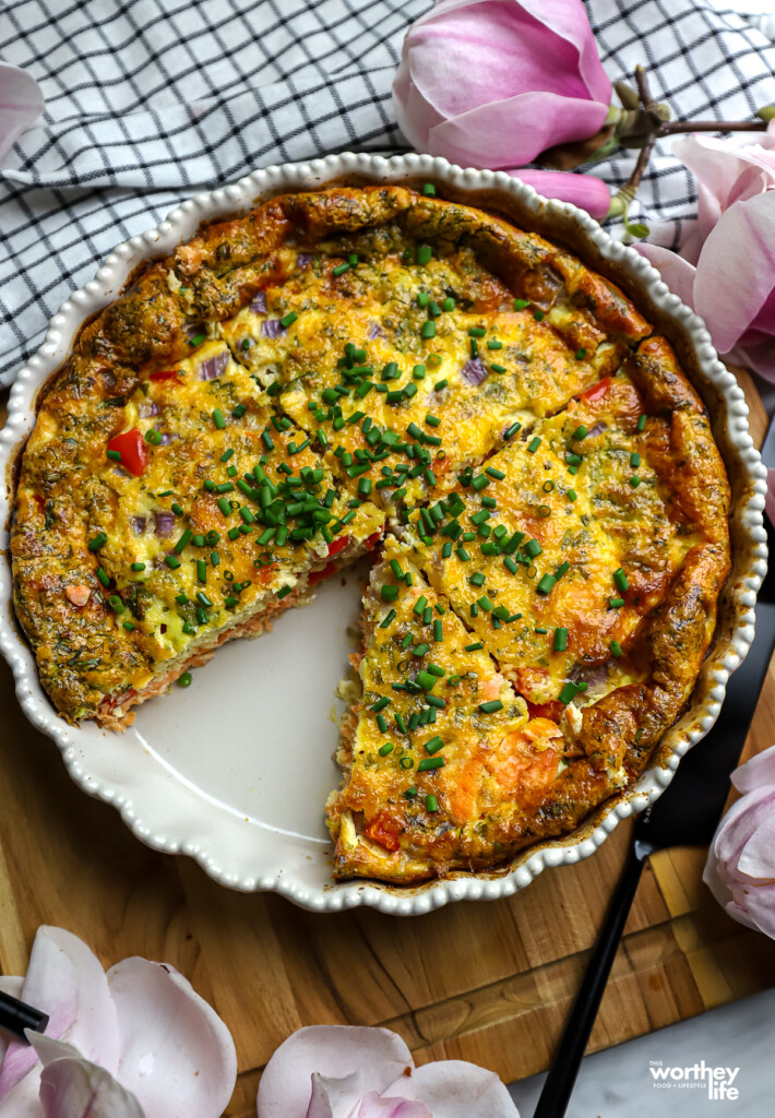 Baked quiche in pie dish with one piece cut