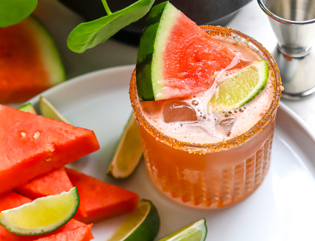 A Watermelon cocktail with fresh watermelon on a white plate