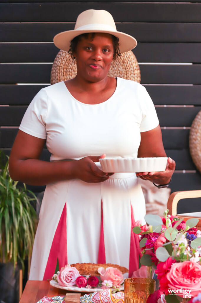Black woman holding a quiche at an outdoor brunch 