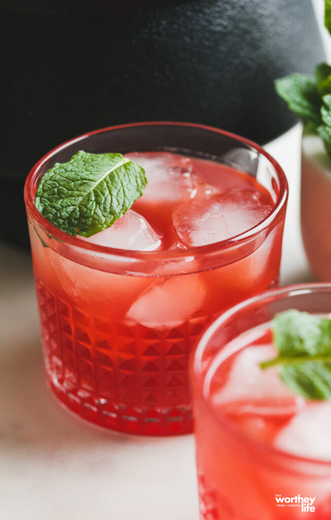 two glasses of raspberry cocktails with ice and fresh mint