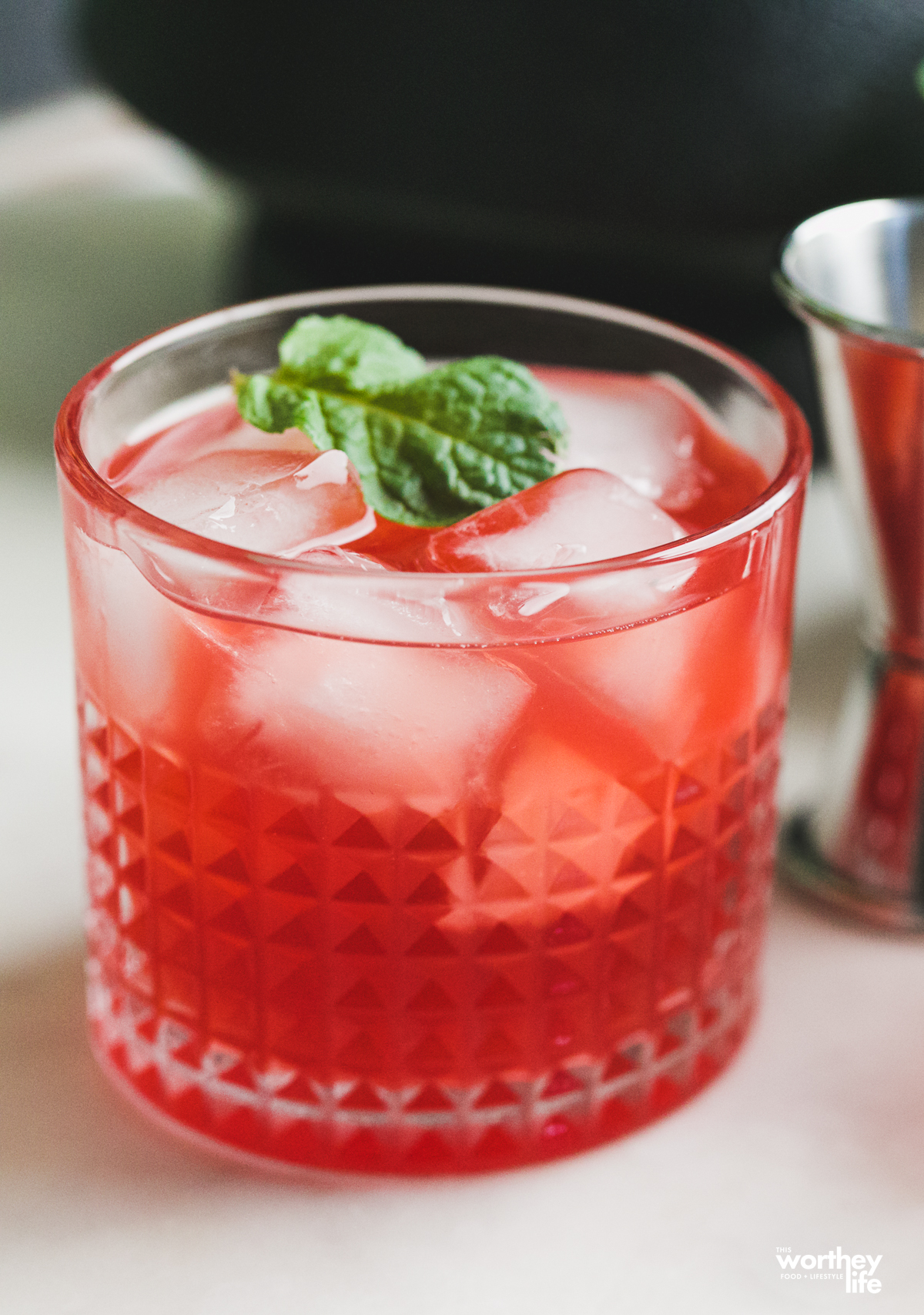 A raspberry cocktail with rum in it on a white surface