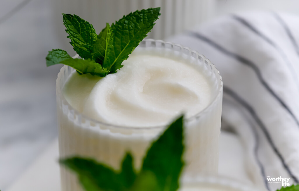 A partial view of our frozen coconut margarita garnished with fresh mint. 