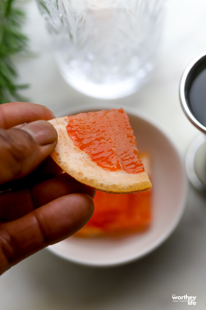 a man holding a slice of grapefruit 