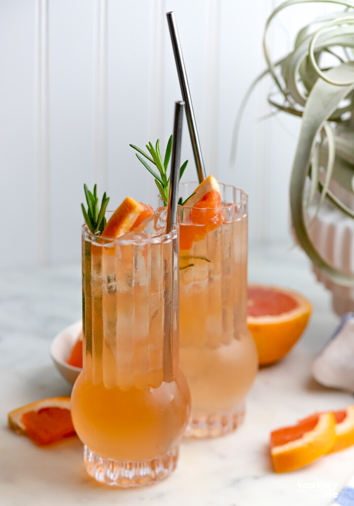 Two Rosemary Palomas in cocktail glasses with white backdrop