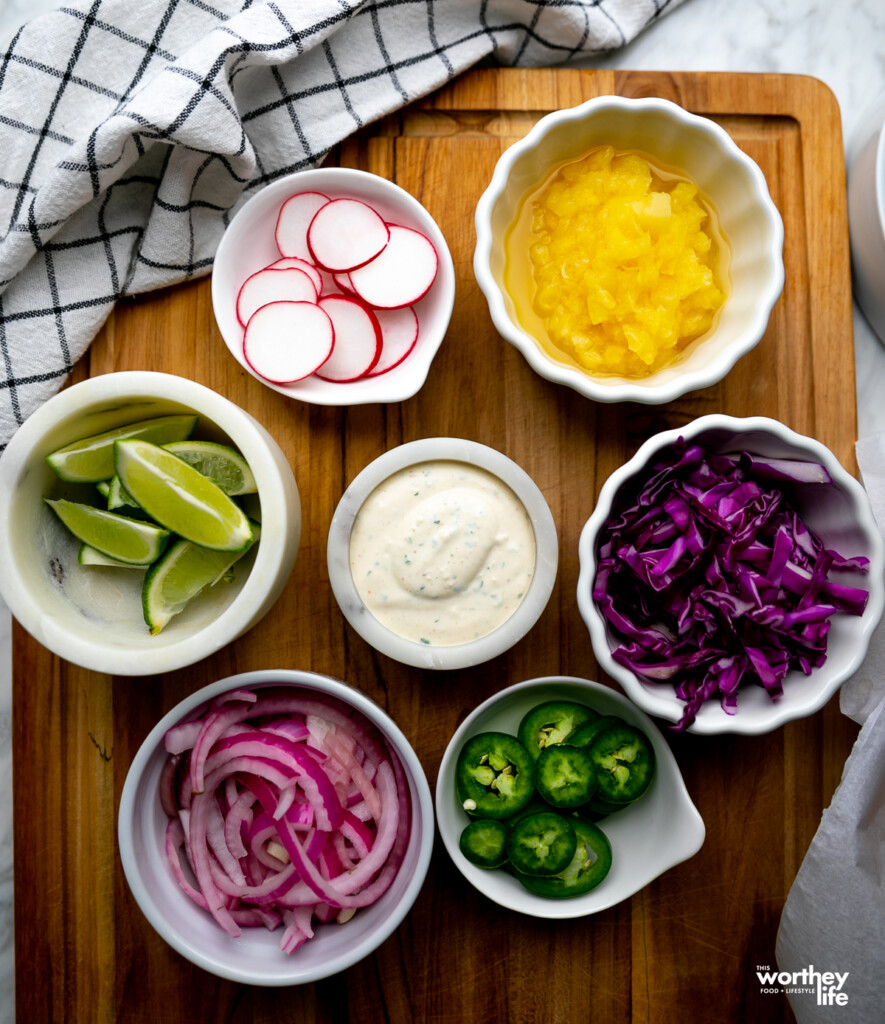 Fresh toppings for fish tacos on cutting board