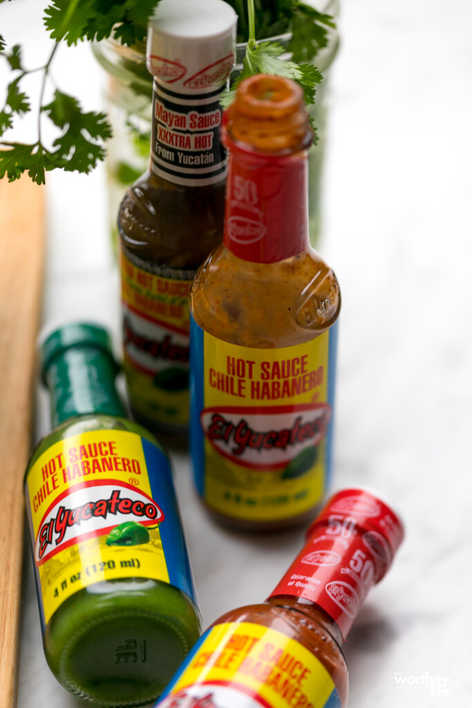 three bottles of el yucateco hot sauce