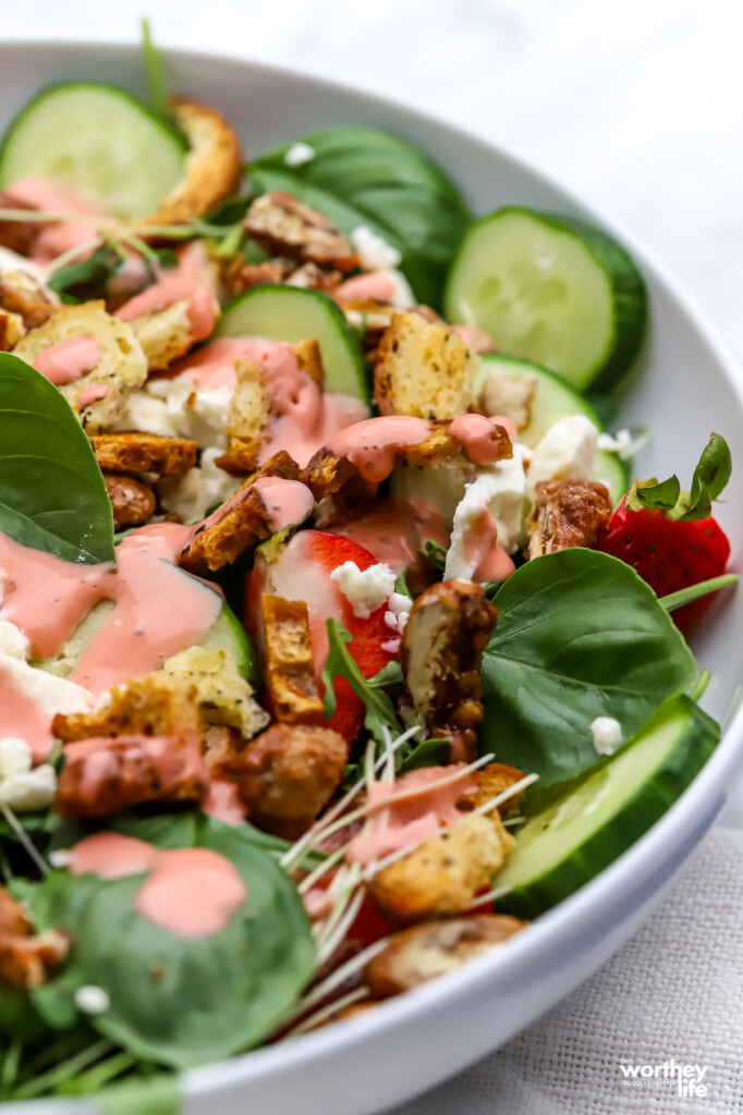 Side view of our Strawberry Arugula Salad in a white salad bowl. 