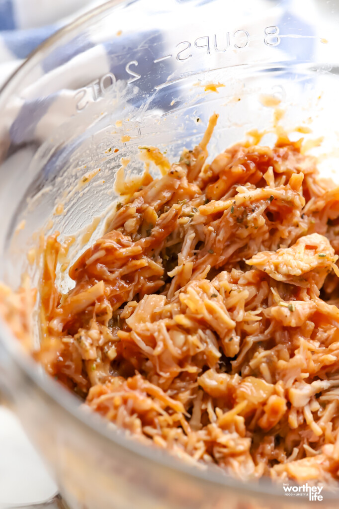 Cooked shredded chicken with barbecue sauce and Italian seasoning.