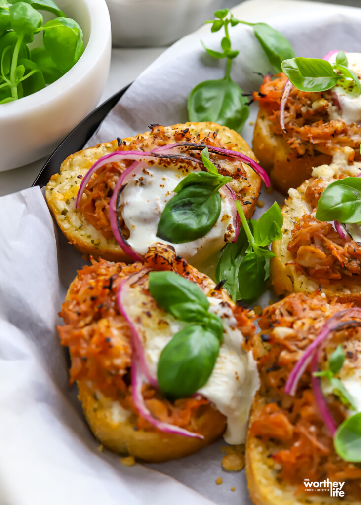 a platter lined with parcment paper with slices of BBQ Texas Toast Pizza.