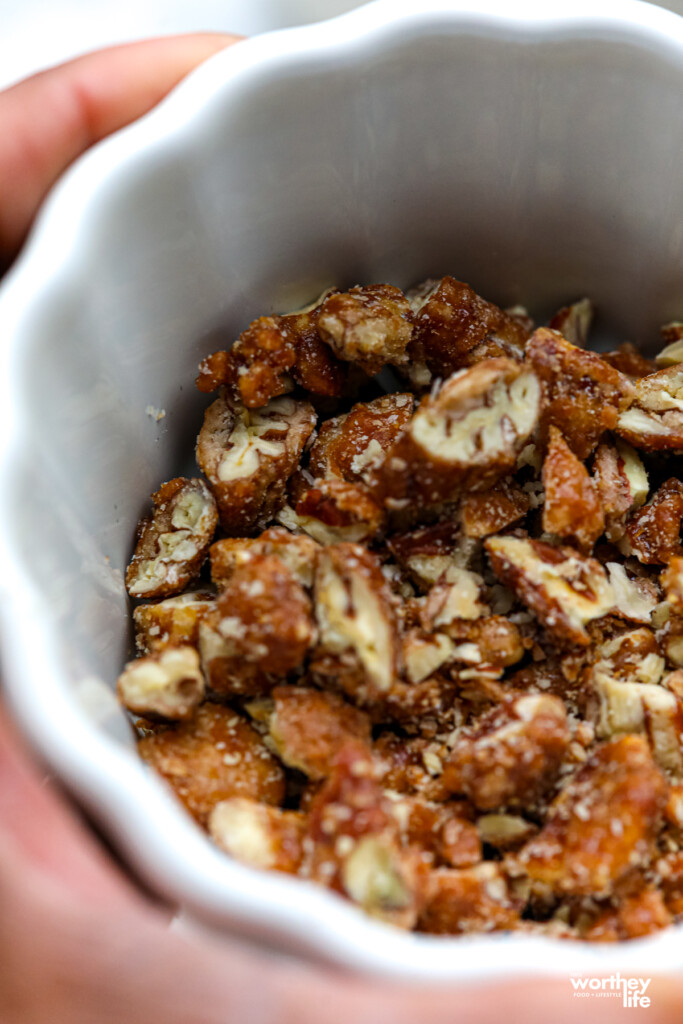 A small ramekin with chopped praline pecans.