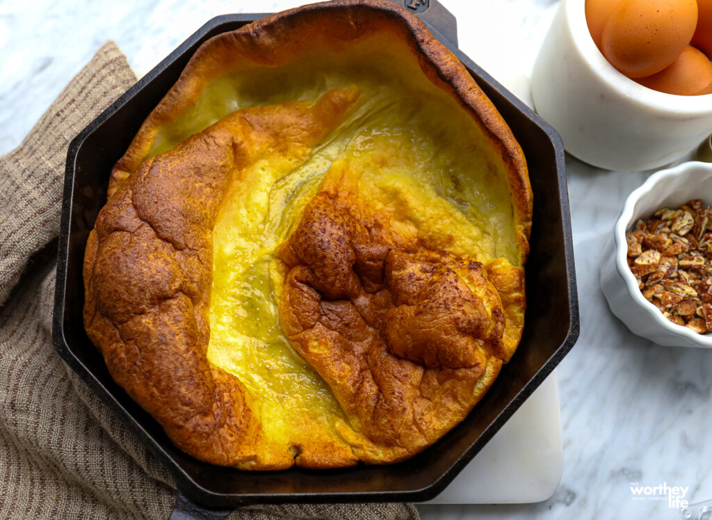 Baked Dutch Baby in a cast iron skillet.