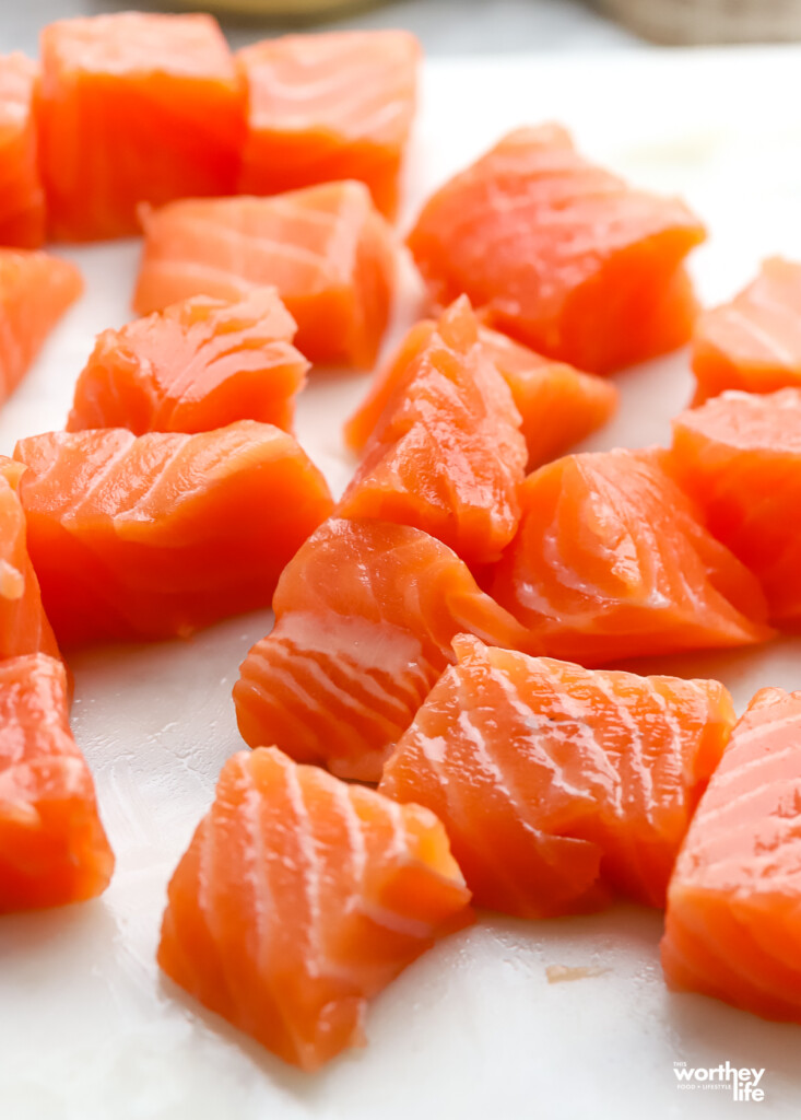 Cubes of fresh salmon on a marble cutting board. 