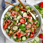 Strawberry Arugula Salad on white background with utensils and cloth napkin