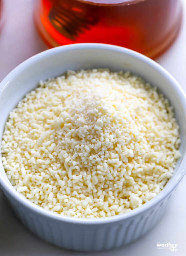 A small white ceramic bowl filled with finely grated Cotija cheese. 
