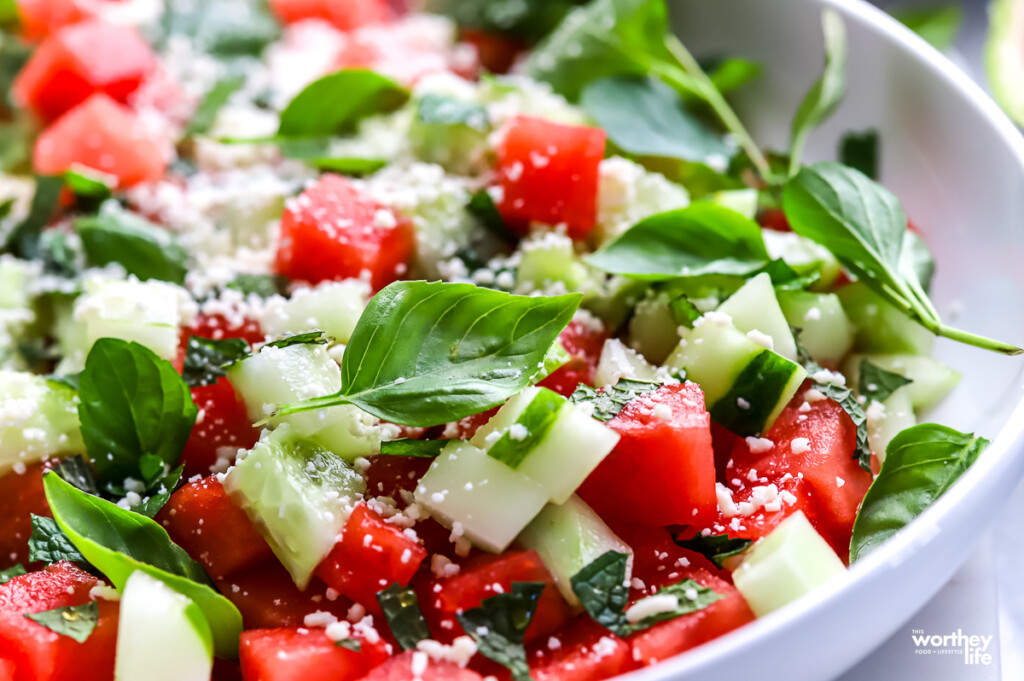 A serving bowl filled with watermelon cucumber basil salad.