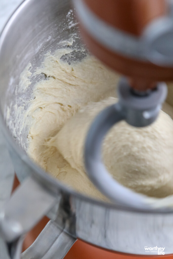 Dough being kneaded in a stand mixer fitted with a dough hook. 