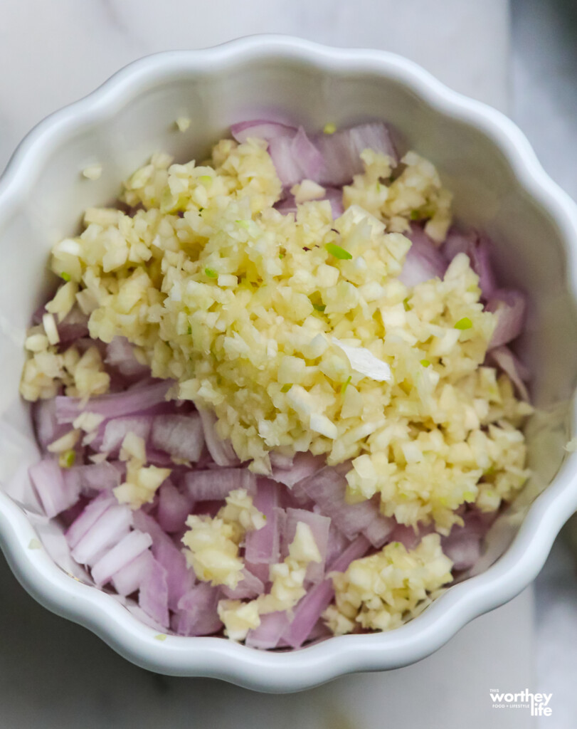 Diced shallots and garllic in a white bown. 