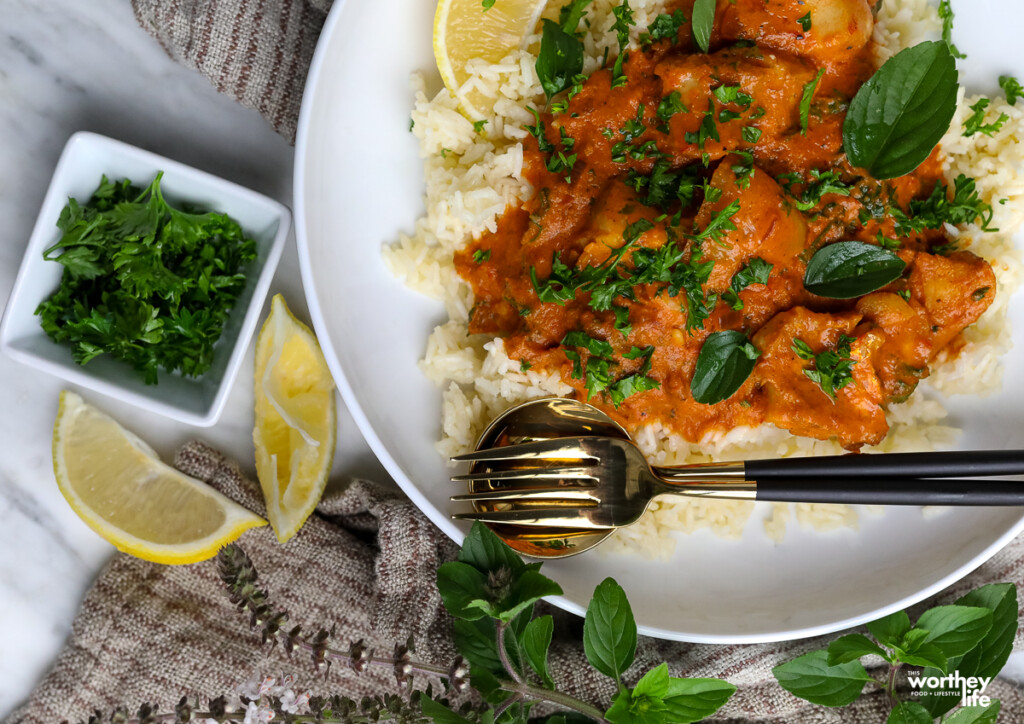 a place of tomato stew with fresh lemon wedges