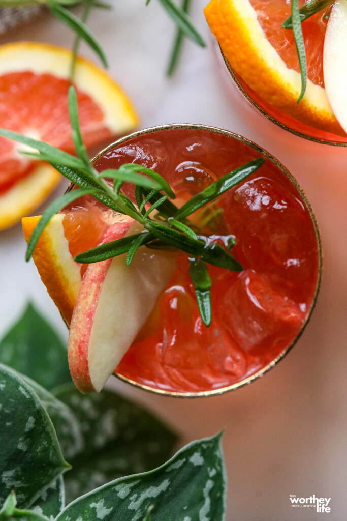 Our Spiced Cranberry Mule in a serving glass with apple slices and rosemary. 