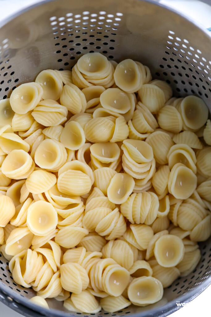  An aluminum colander with pasta. 