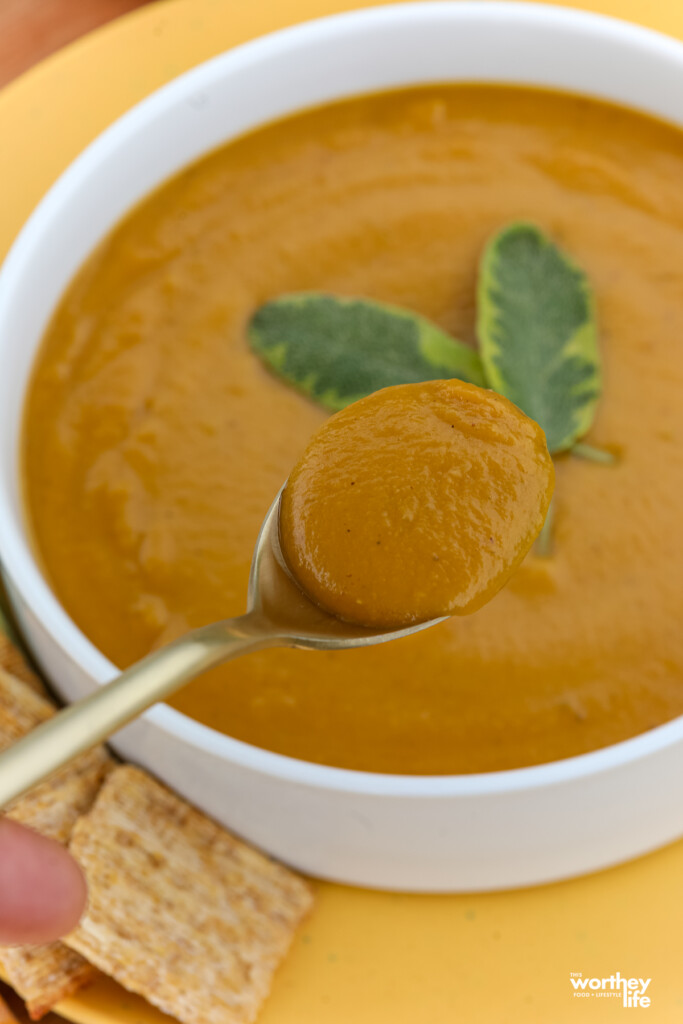 A man holding a golden spoon filled with soup