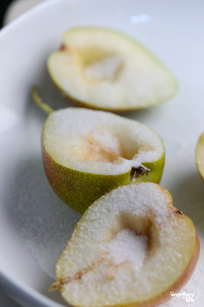 sugared pears cut in halves on white plate