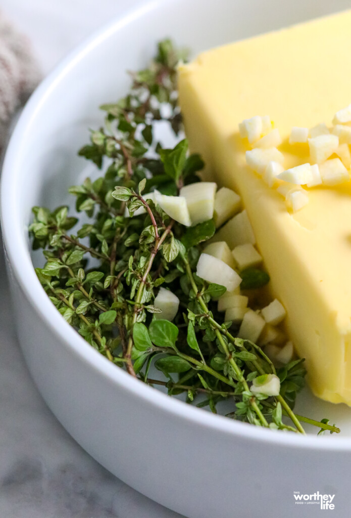 fresh herbs and butter in a white bowl