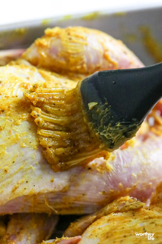 Brushing the Cornish Hens with curry seasoning mix