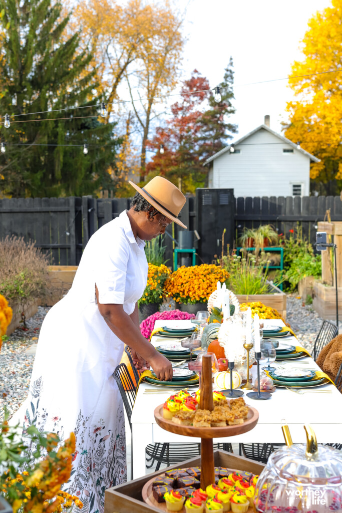 woman setting a table for Thanksgiving outside