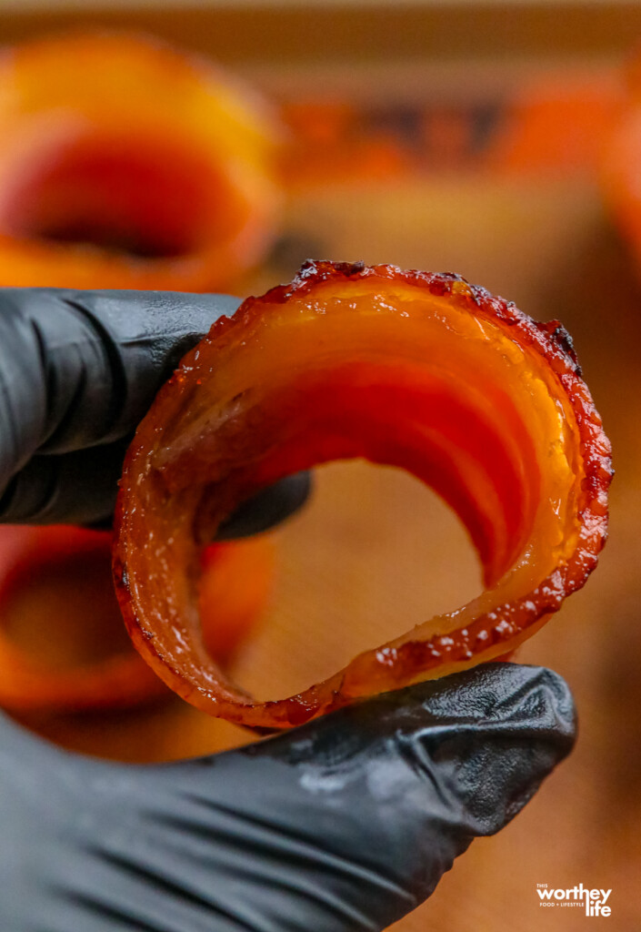 a man holding a bacon ring cup