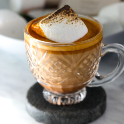 A single serving cup of gingerbread latte topped with a toasted marshmallow.