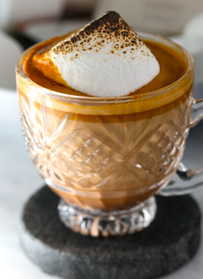 A single serving cup of gingerbread latte topped with a toasted marshmallow.