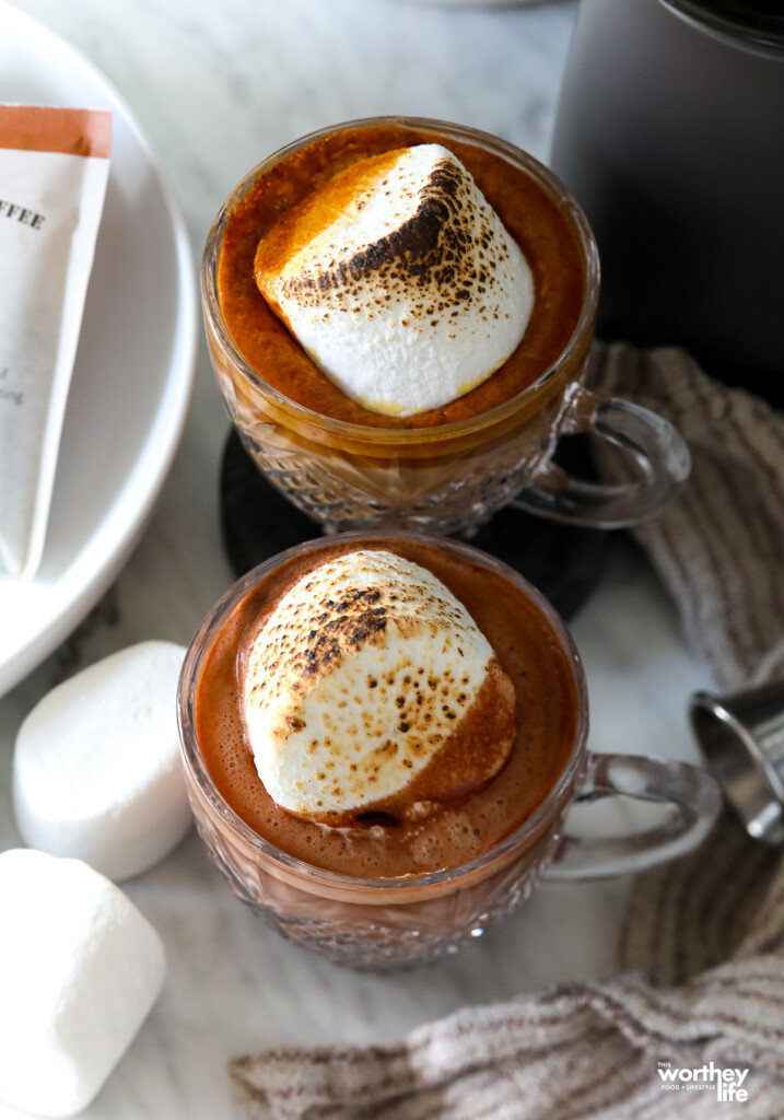 Two Gingerbread Lattes served in coffee cups and topped with a toasted marshmallow. 