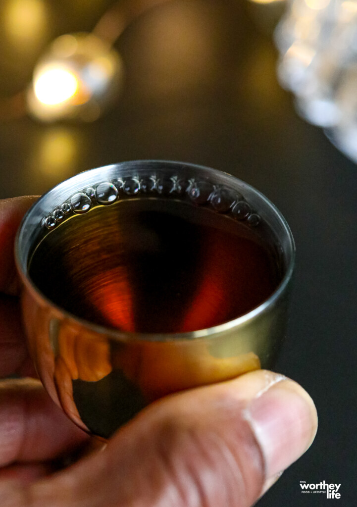 man's hand holding cranberry juice for a cocktail