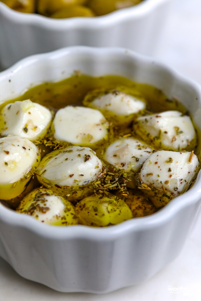 mozzarella cheeseball marinating in small white bowl