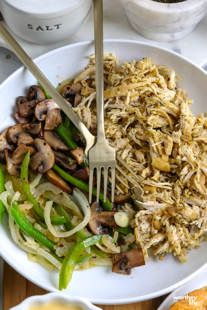 shredded chicken and sauteed veggies on white plate