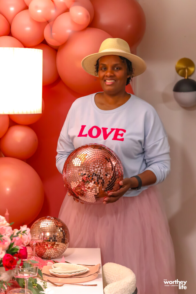 woman holding a rose gold disco ball at a galentine's party